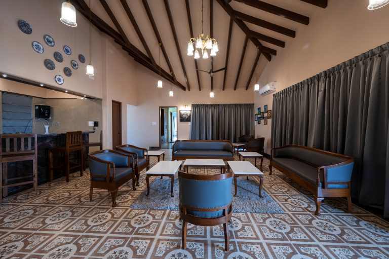 The spacious drawing room of a 4BHK cottage villa in Alang, adorned with comfortable sofas, soft rugs, and elegant décor