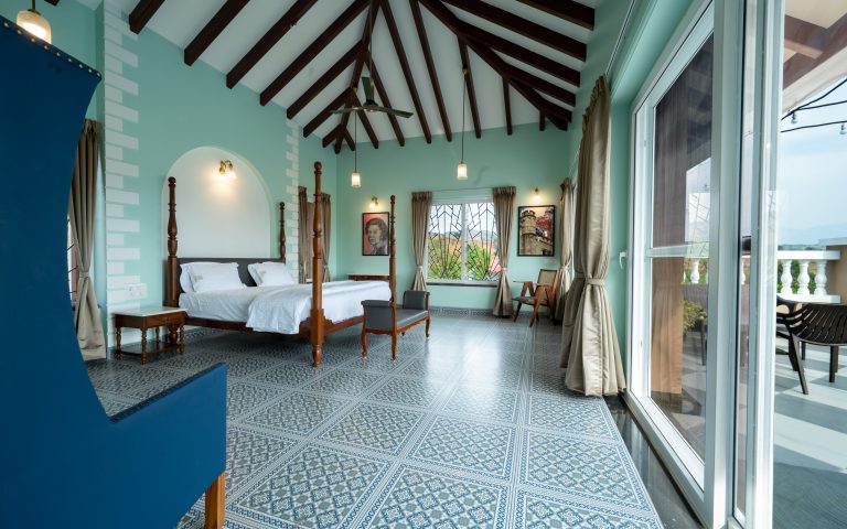 Bedroom 1 of a 4bhk Alang cottage villa, featuring a scenic view of serene surroundings or lush landscapes, with comfortable furnishings and natural light creating a peaceful retreat