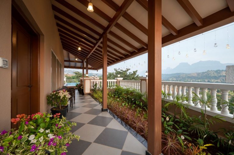 The entrance of a 4bhk Alang cottage villa, framed by lush greenery and offering a scenic view of the surrounding landscape, creating a welcoming and picturesque arrival experience.
